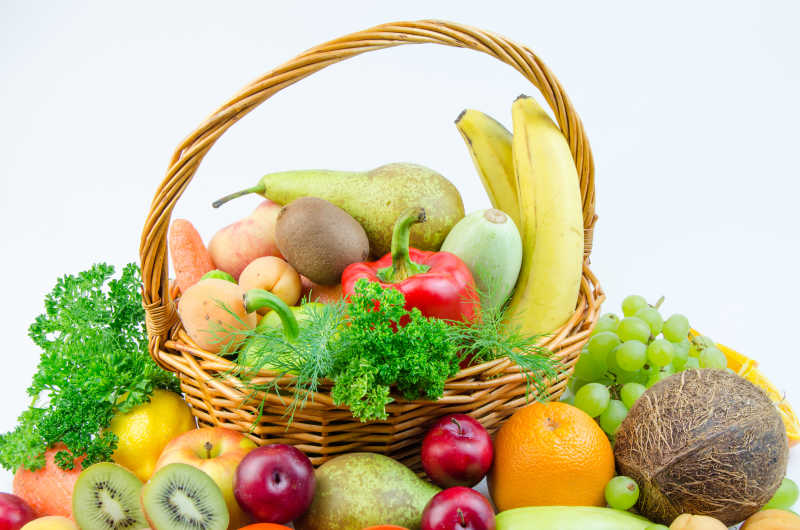 灰白色背景下堆放的香蕉椰子葡萄梨辣椒等新鲜的水果和蔬菜