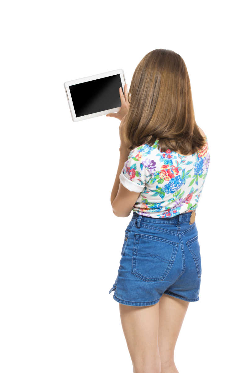 白色背景下使用平板电脑的美女背影