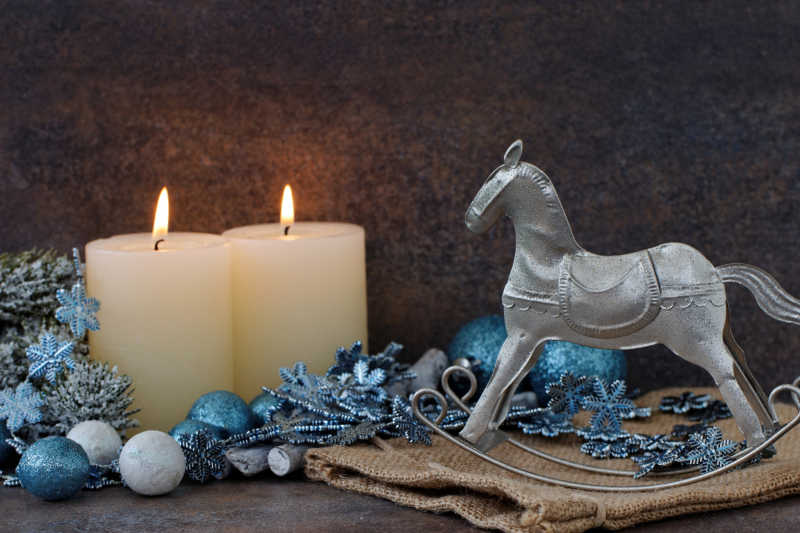 圣诞节燃烧的白色的蜡烛和摇马装饰品