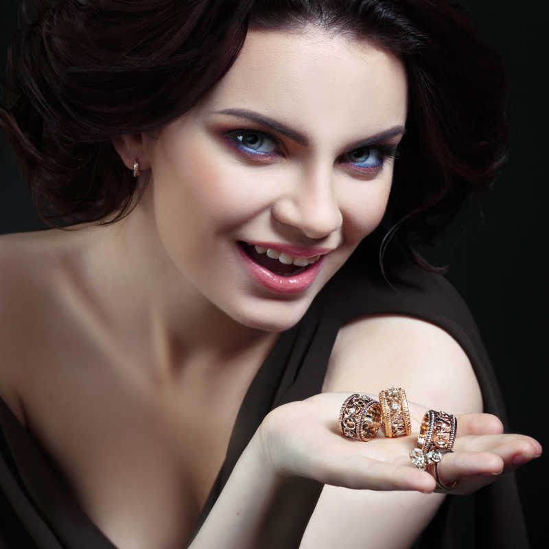 一个女人的手上带着很多戒指