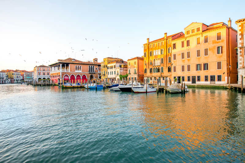 晴天下威尼斯运河上五颜六色的哥特式建筑和小船