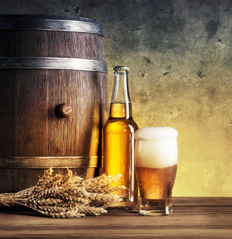 木桌上的木桶和金黄色的小麦以及啤酒