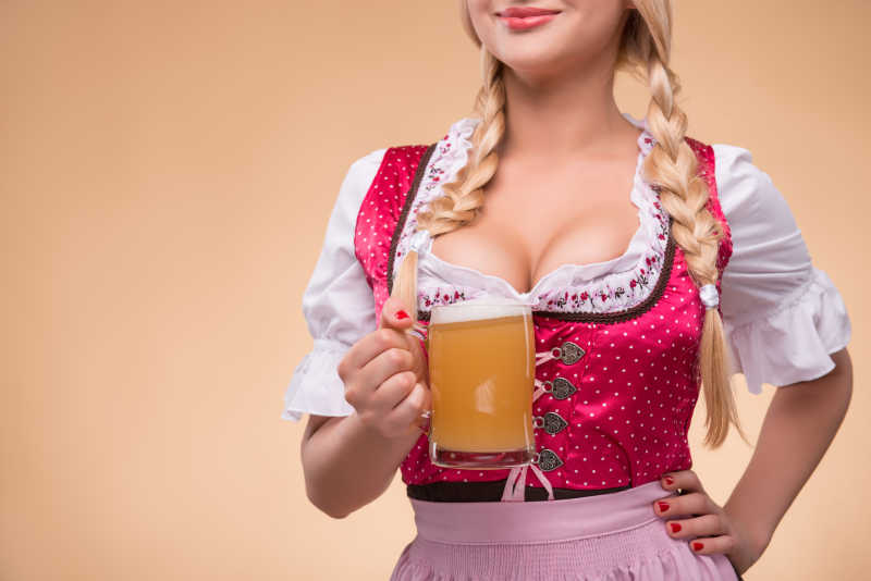 年轻性感的金发女郎展示一个大啤酒杯