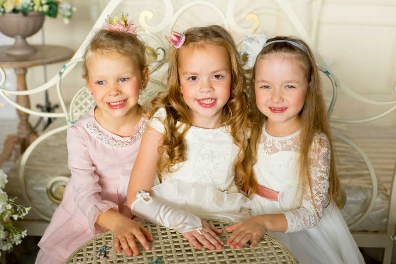 桌子旁的三个可爱的小女孩