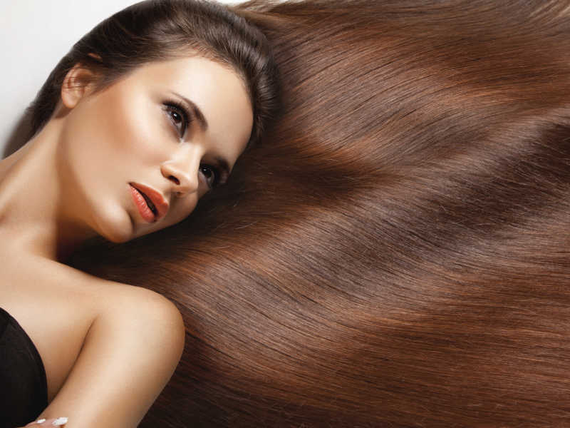 美丽的女人与棕色的有光泽的长直发