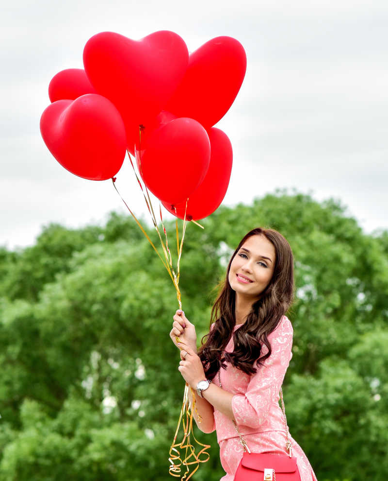 年轻美女拿着红色气球