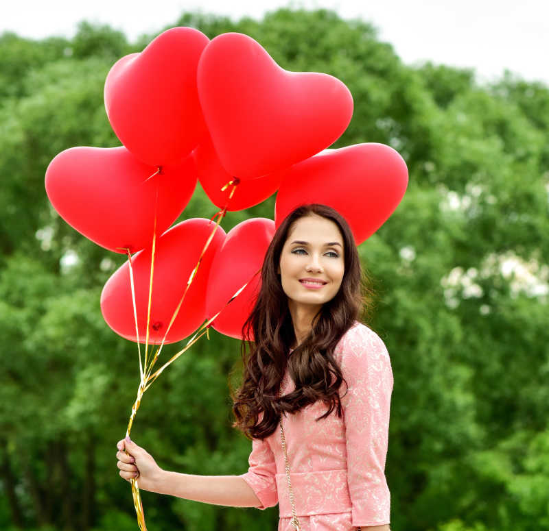 年轻的女子拿着红色气球