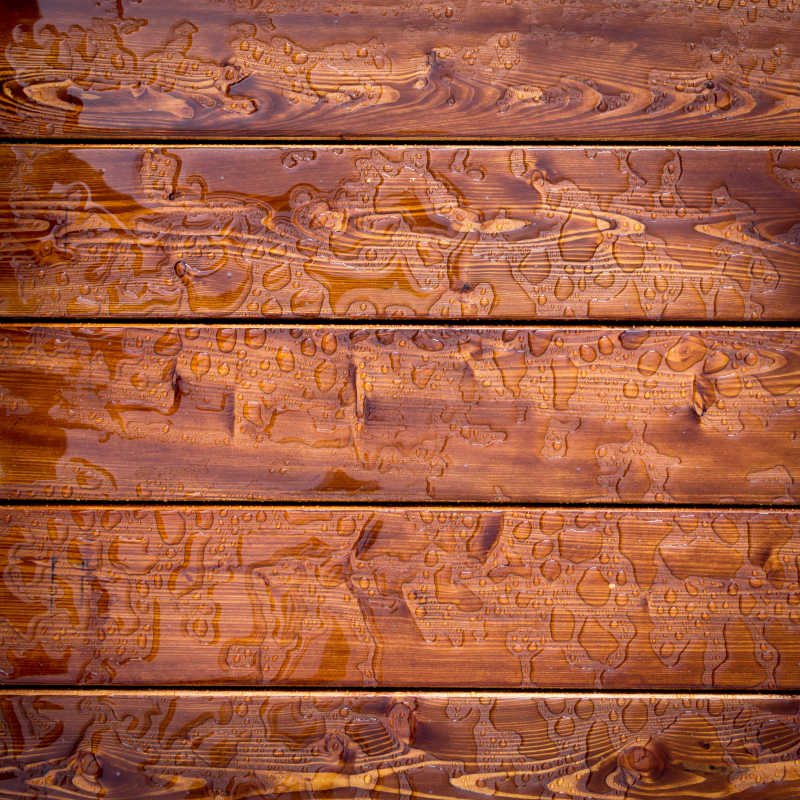 棕色木板上的雨滴