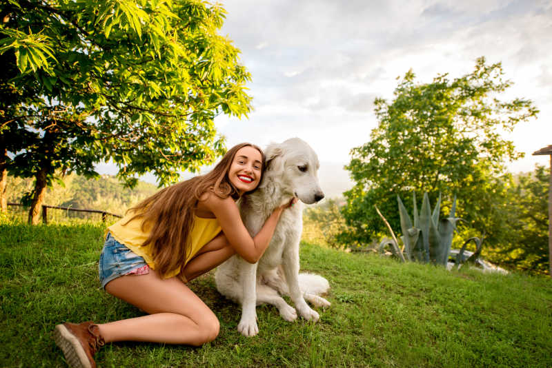 快乐的女孩与她的白色牧羊犬