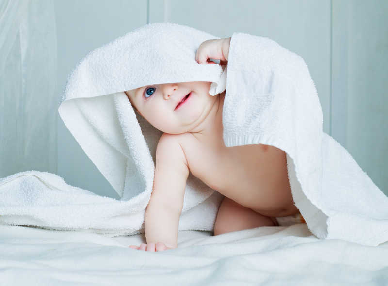 床上可爱的毛巾下的宝宝