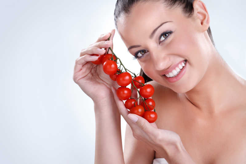 女人带着一束樱桃西红柿