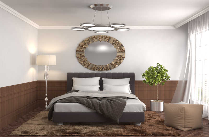 卧室床上方的圆形装饰和两旁的绿植和灯