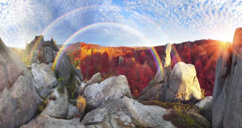 秋季森林天空中的彩虹和岩石