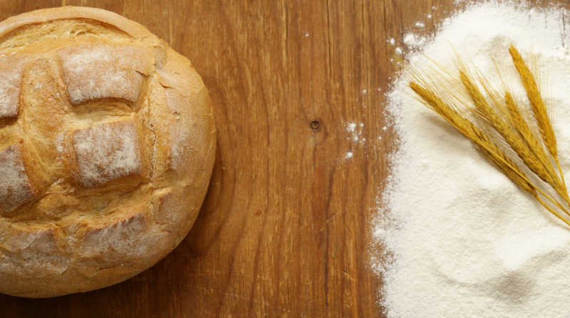木桌上的美味面包和面粉