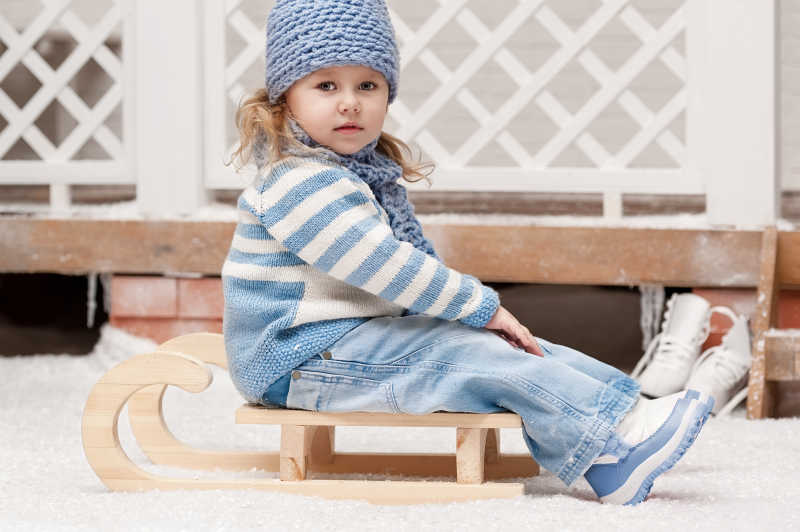 坐在雪橇上的小女孩