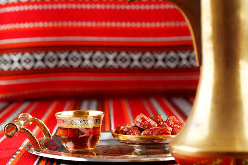 放在阿拉伯织物上的枣茶和红枣