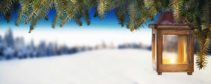 雪地背景上挂在云杉树枝上的圣诞灯笼