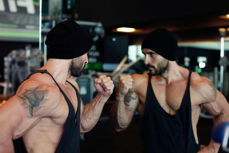 在健身馆镜子上展示肌肉的男子