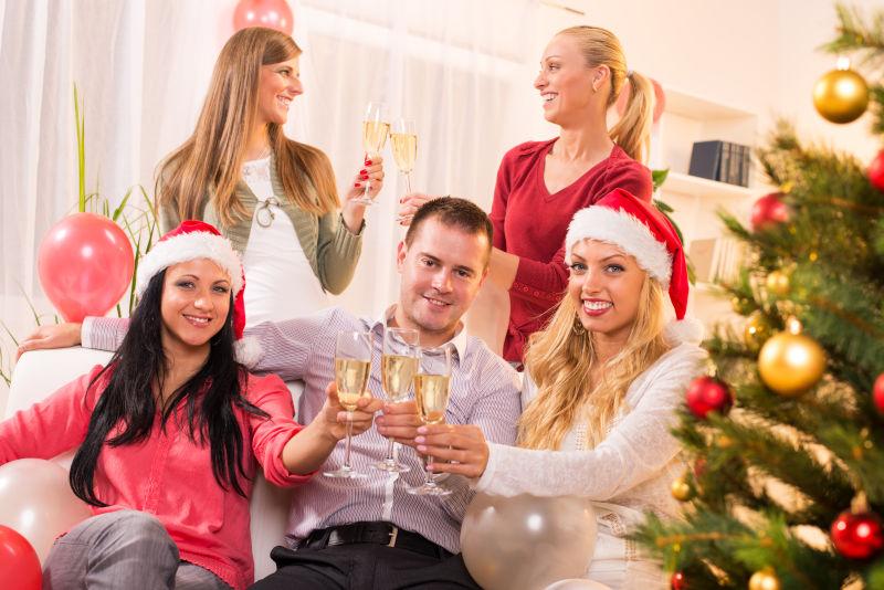 快乐的朋友们在家里用香槟庆祝圣诞节