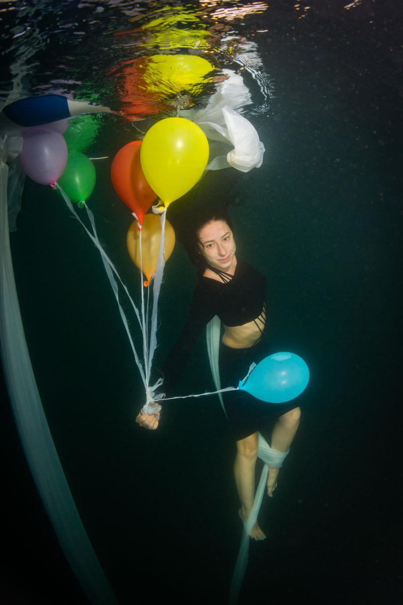 年轻优雅的女人在水下气球上飞翔