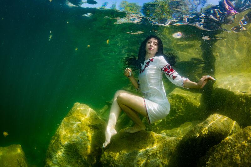 穿着乌克兰刺绣装扮的年轻优雅女子在水下