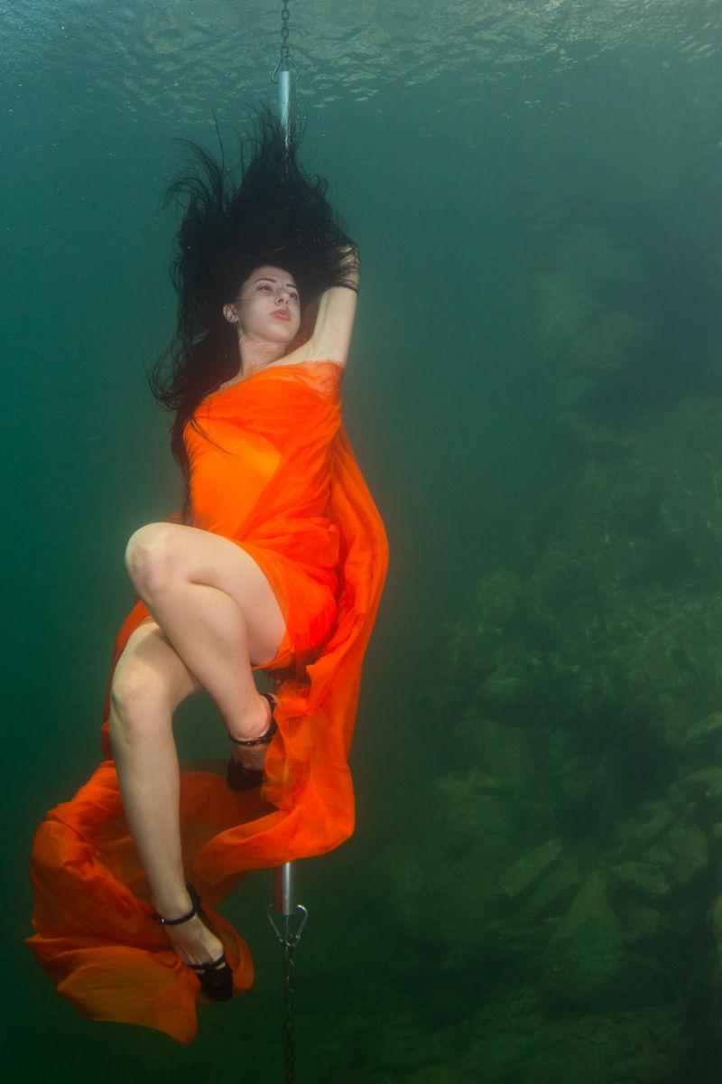 美丽窈窕的女孩跳脱衣舞在水下