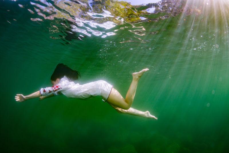 在水下穿着乌克兰刺绣装扮的年轻优雅的女子