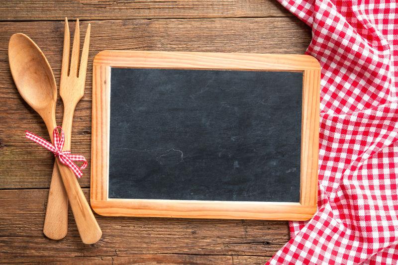 木桌上的红色格子餐布木质的黑板和木质的餐具