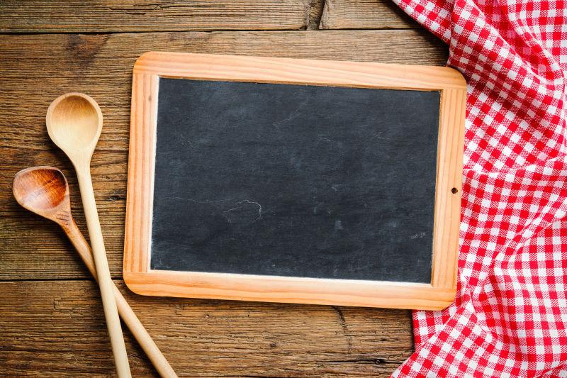木桌上的红色格子台布黑板和木质餐具