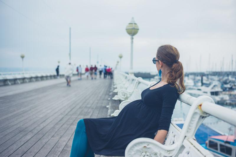 码头上的坐着的外国孕妇