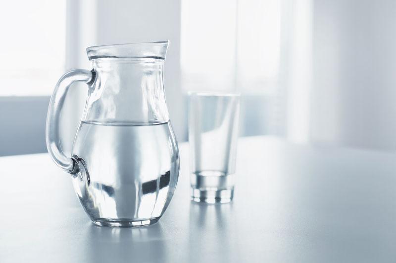干净的桌子上的水壶和水杯