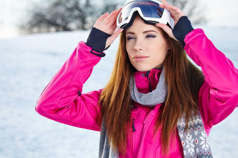 冬季雪地上戴着护目镜的年轻美女