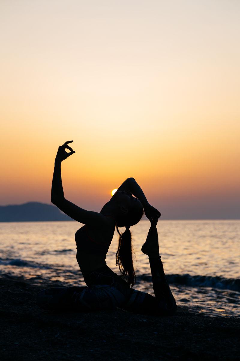 海滩上练习瑜伽的女子剪影