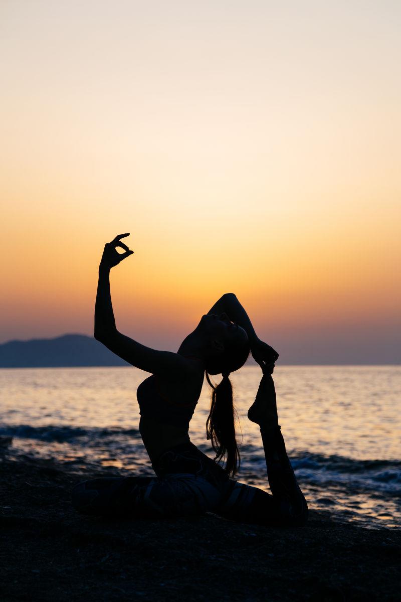 日落时练习瑜伽的女子