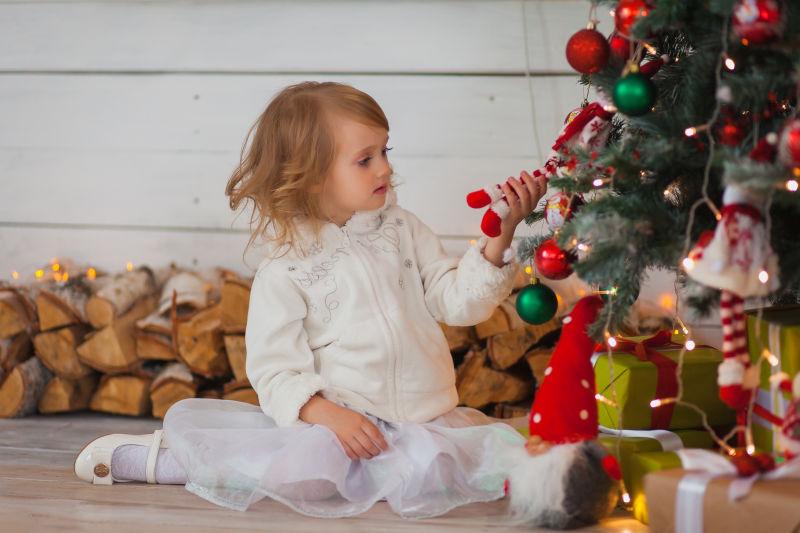 圣诞树旁边可爱的小女孩