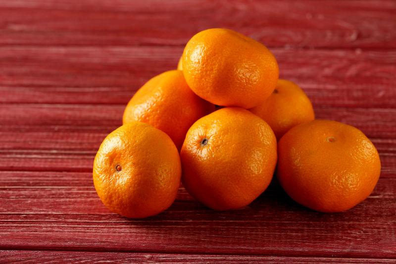 红木桌上成熟成堆的黄色橘子