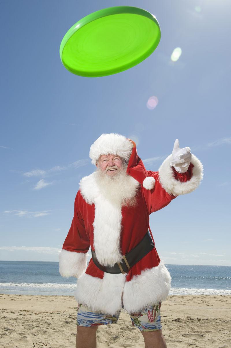 沙滩上圣诞老人玩飞盘