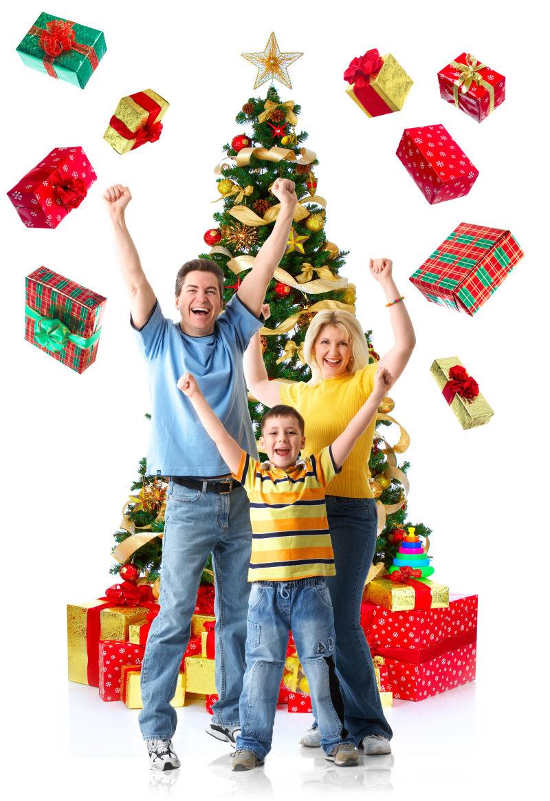 白色背景上站在圣诞树前庆祝圣诞节的一家人