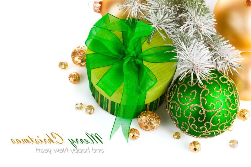 白色背景上的绿色的礼品盒和绿色球形装饰品