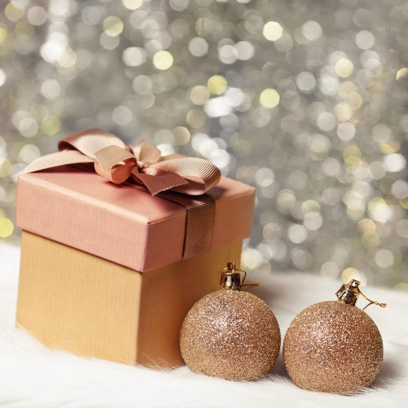 银色光斑背景下的卡其色圣诞节礼品盒和装饰品
