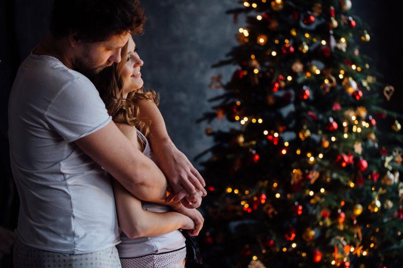 穿着漂亮的年轻夫妇穿着漂亮的圣诞树