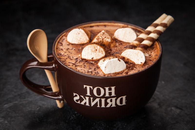 黑色桌上的一杯带有棉花糖的热巧克力