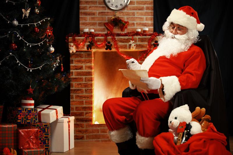 圣诞老人坐在壁炉前阅读