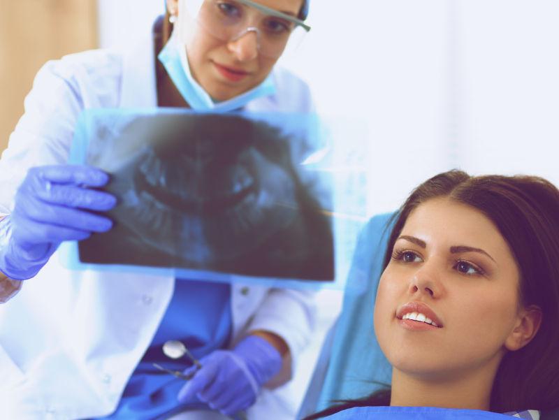 正在给病人看x光片的牙医