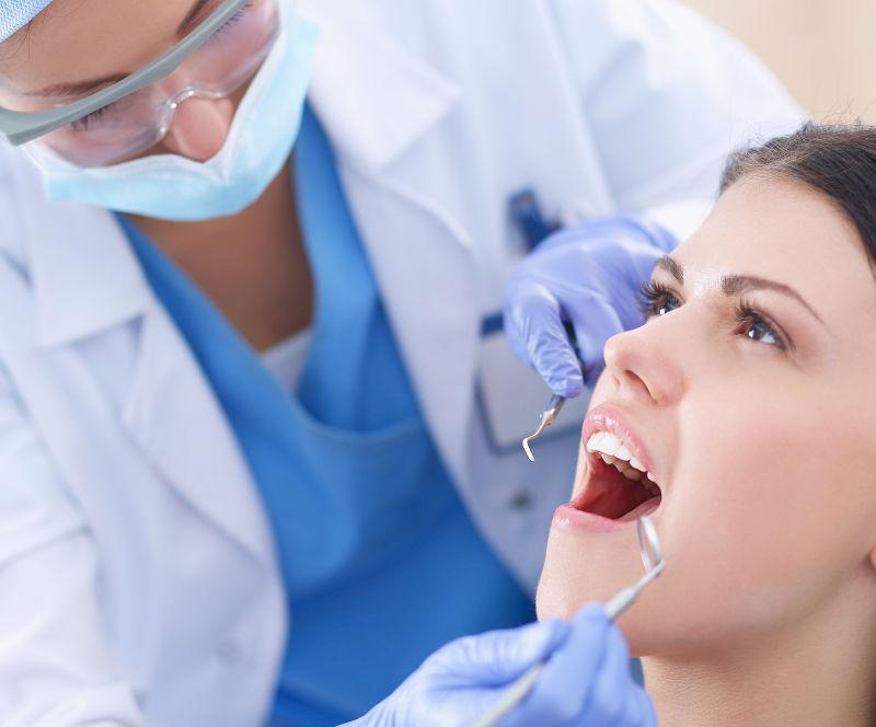 牙医正在为女病人检查牙齿