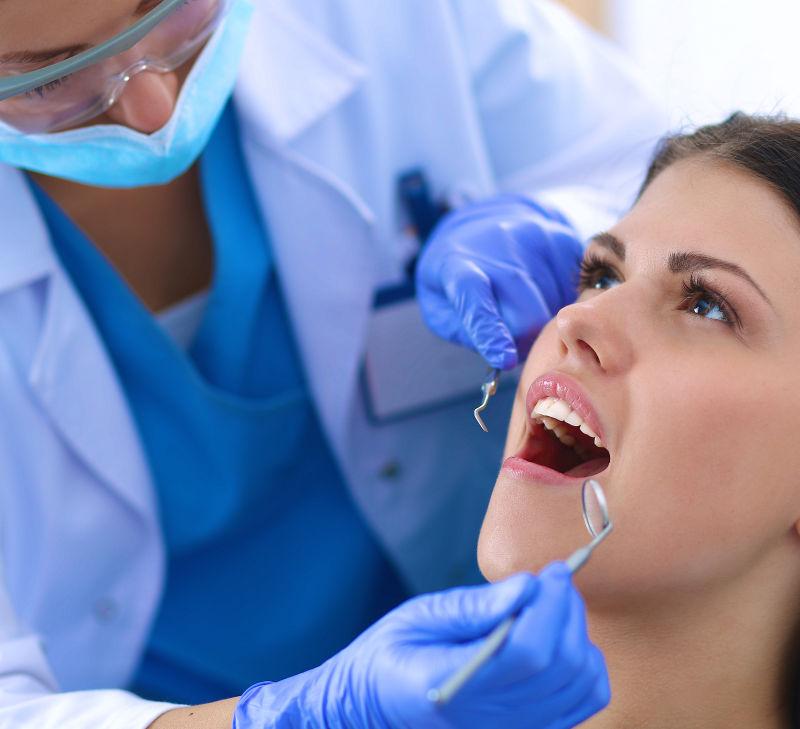 牙医在为年轻美女检查牙齿
