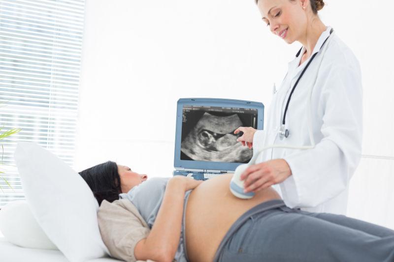 医院的女医生为孕妇做超声波检查