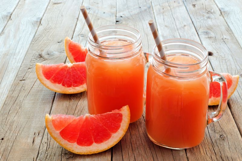 木板上的红柚和美味的柚子果汁