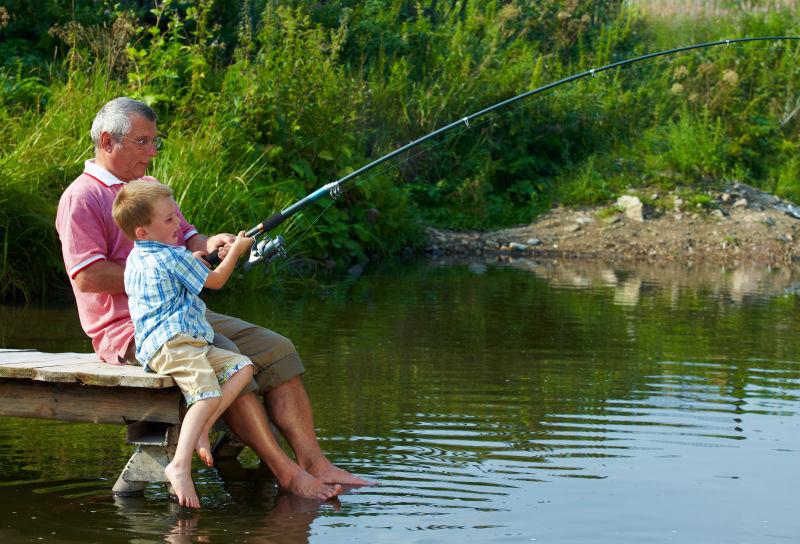 带着外孙在钓鱼的祖父