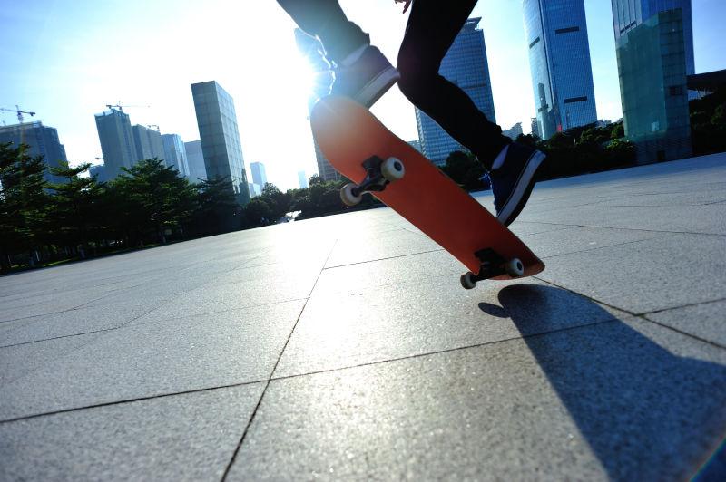 日出城市广场上玩滑板的年轻人
